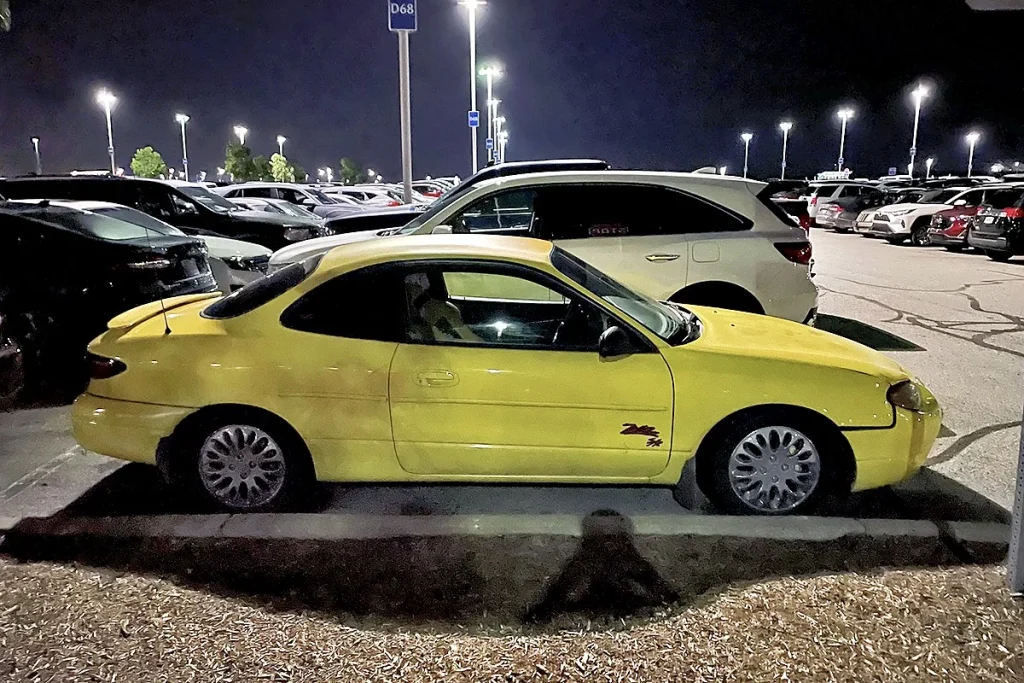 yellow 1999-2000 Ford Escort ZX2 parked at night among other cars in a lot